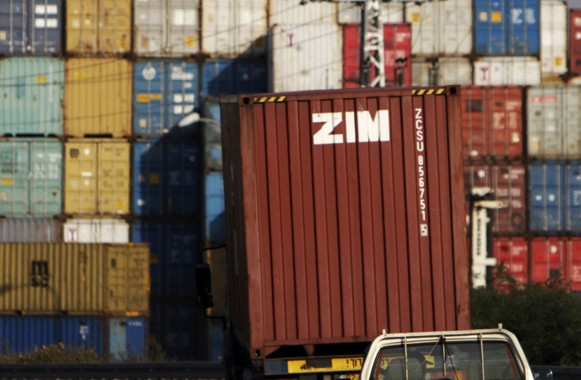 Cars drive behind a truck transporting a Zim container just outside Israel's port of Ashdod February 23, 2012.