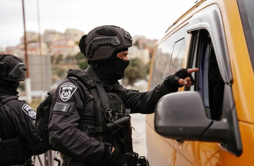 The Israeli police pointing towards the inside of a car.