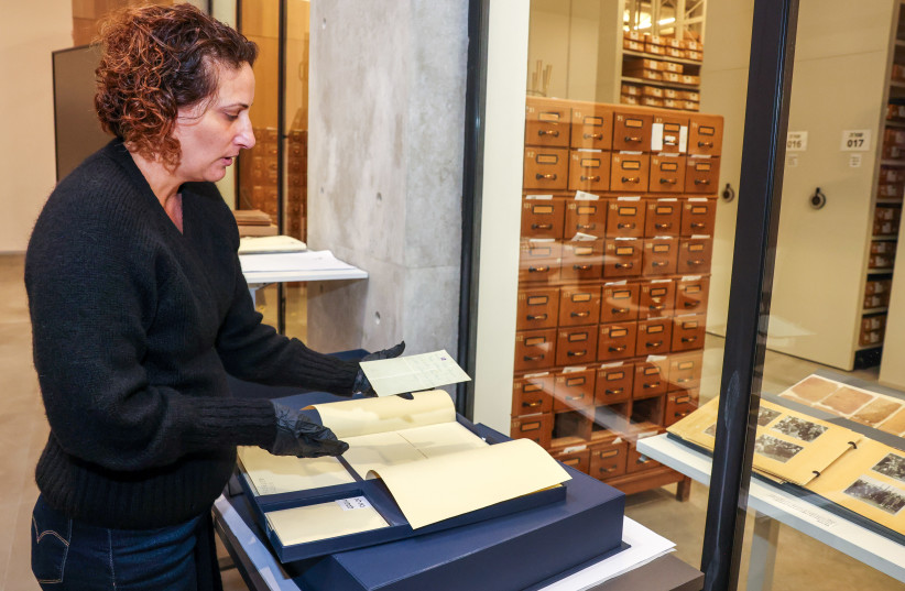Orit Noiman, head of private sector document collection at Yad Vashem, shows some materials collected from survivors and their families in the museum’s new archive center.