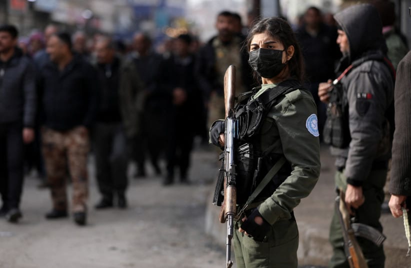 A Kurdish internal security forces member stands guard with a weapon as Syrian Kurds attend a protest in solidarity with the people in the neighborhoods of Sheikh Maqsoud and Ashrafieh in Aleppo, in Hasakah, Syria January 7, 2026.