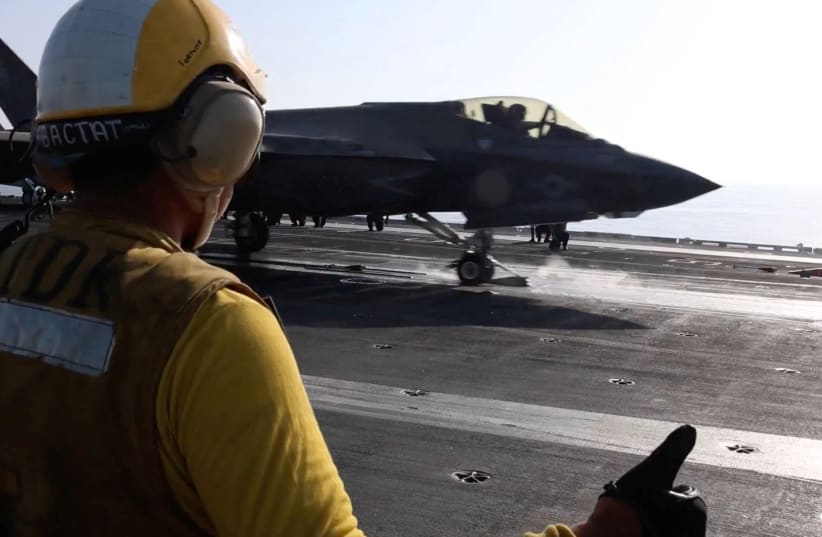 A screengrab from a video released by CENTCOM shows a flight deck crew member signaling an F‑35 jet on an aircraft carrier, in this image obtained from social media released on February 28, 2026