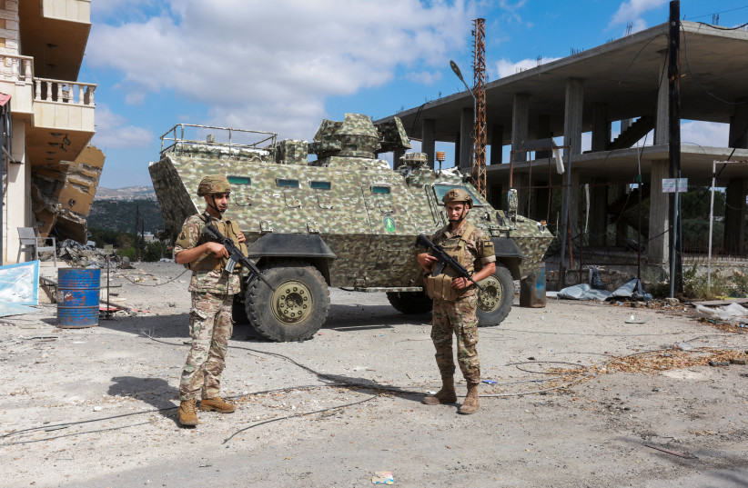 Members of the Lebanese army stand guard next to an armoured personnel carrier, as people make their way back to their homes, following a peace deal between the United States and Iran, in Bir Al-Salasil, Tyre district, southern Lebanon, June 15, 2026.