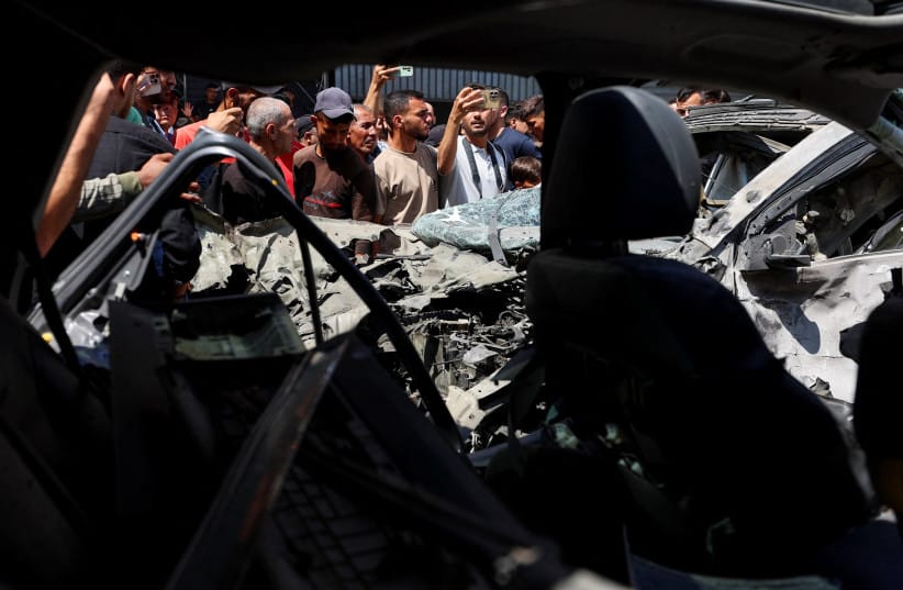 Palestinians inspect damaged vehicles at the site of an Israeli strike, in Gaza City, June 22, 2026.