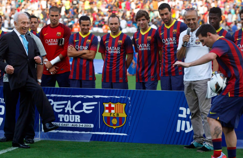 FC Barcelona player Lionel Messi controls a ball passed by Israeli President Shimon Peres during a training session on Aug. 4, 2013 in Tel Aviv.
