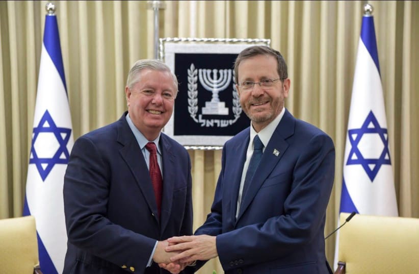 Republican US Senator Lindsey Graham (L) and President Isaac Herzog (R) shaking hands, July 12, 2026.