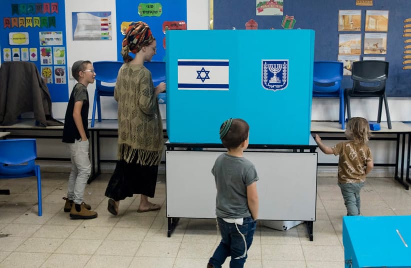 An Israeli woman casts her vote as her children join her during Israel's general elections in Har Homa, in eastern Jerusalem, Nov. 1, 2022.
