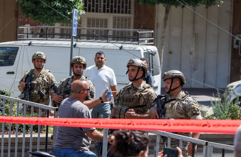 A man on a motorcycle tries to convince Lebanese army officers to let him cross as they cordon off the site of an Israeli strike in the southern suburbs of Beirut, Lebanon, June 14, 2026. 