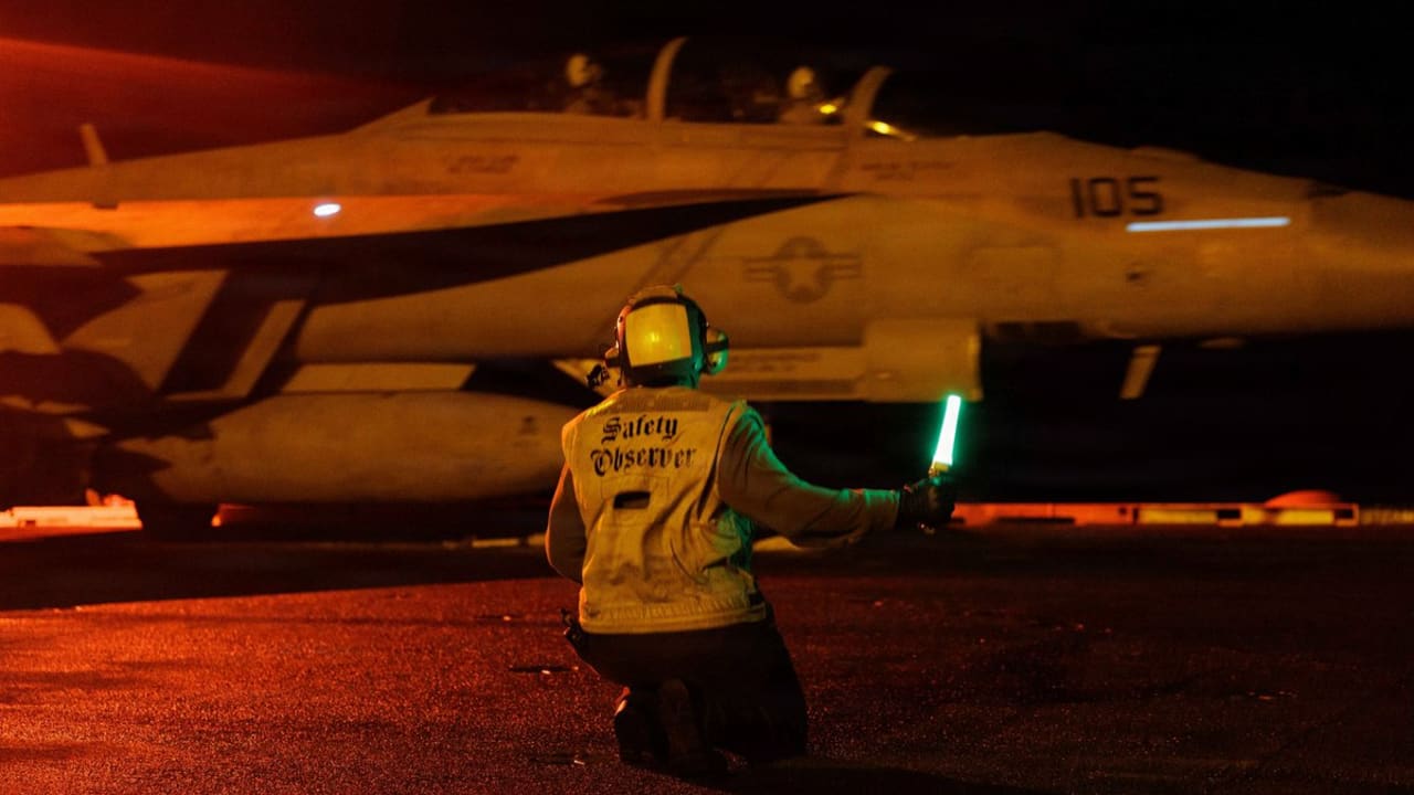 U.S. Sailors signal an F/A-18E Super Hornet on the deck of USS George H.W. Bush (CVN 77) as the aircraft carrier transits the Arabian Sea.