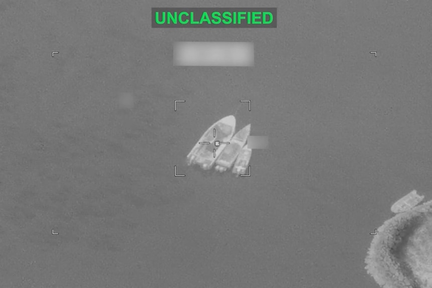 Black and white vision shows several vessels on the water, as seen from above.