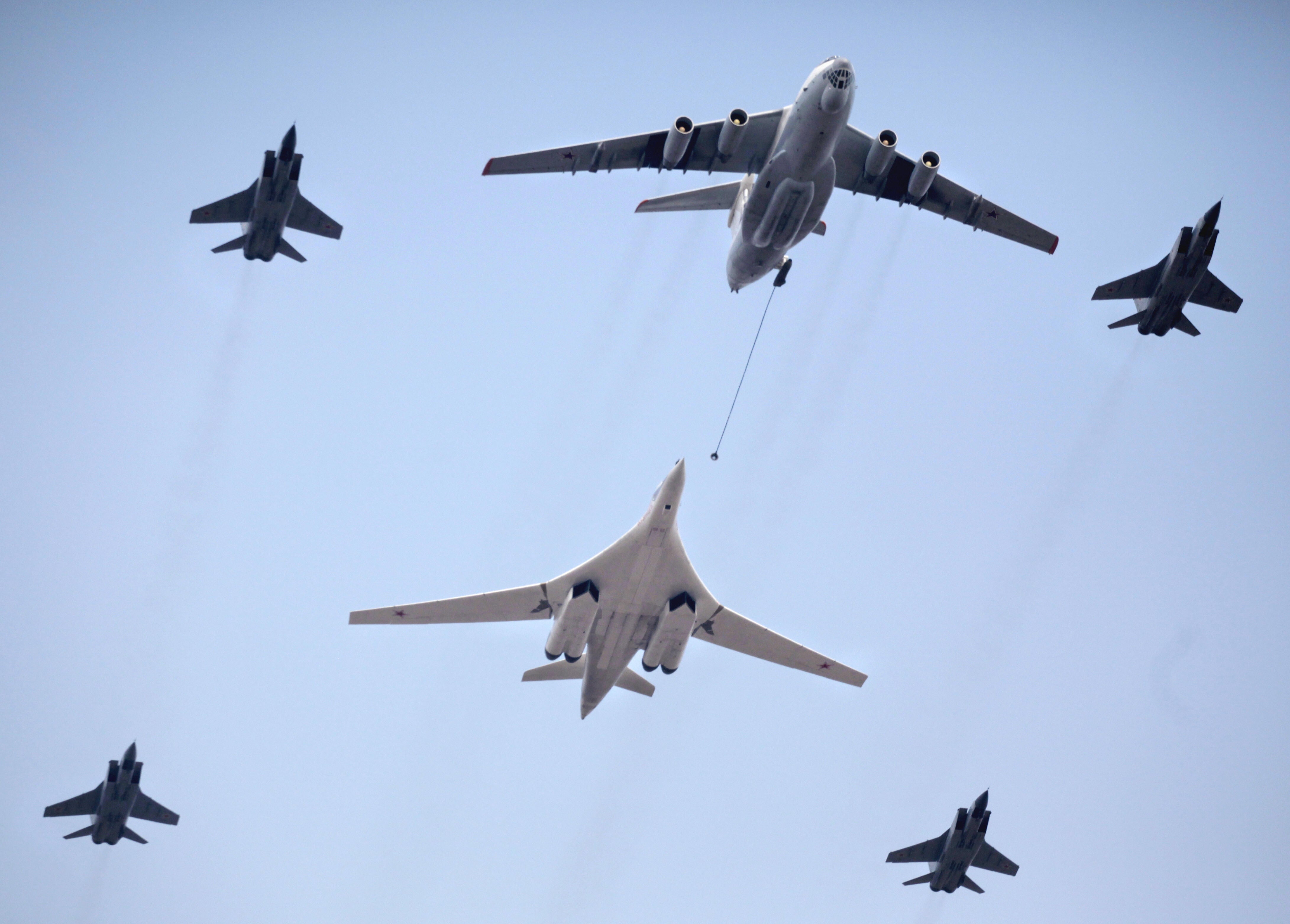 A Russian Tu-160 strategic bomber escorted by fighter jets performs refueling during a Victory Day parade