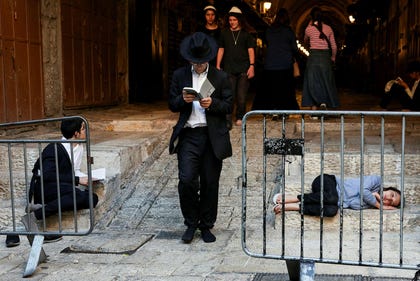 Jewish visitors pray near an entrance of the Al-Aqsa Mosque compound during the holy day Tisha B'Av, in Jerusalem's Old City, Thursday.
