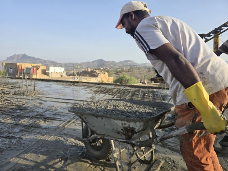 Construction laborers pour a concrete roof in Taiz governorate amid rising building material costs.