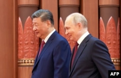 Russian President Vladimir Putin (right) walks with Chinese President Xi Jinping during meeting in Beijing in May.