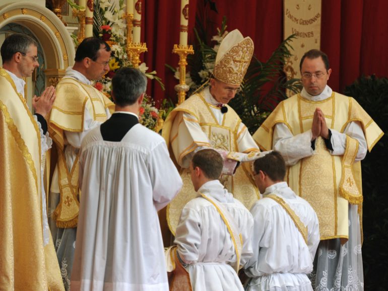Priest's lay their hands on the heads of the future priest's during the ordination to the priesthood of the Society of St. Pius X