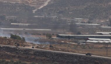 Israeli security forces drive on a road as smoke rises from fires in the area near the settlement of Itamar, in the north of the occupied West Bank.