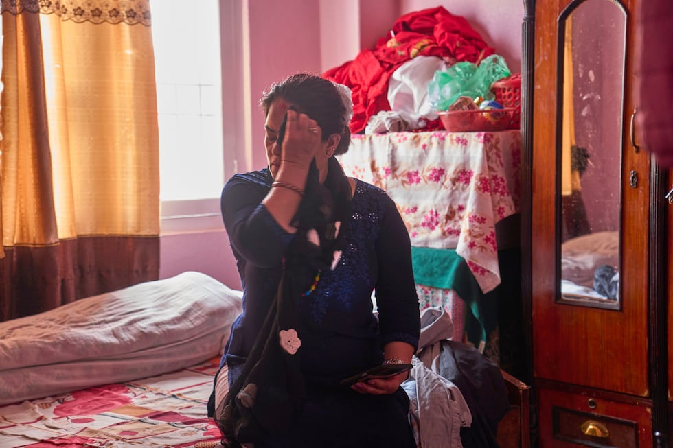 A 54-year-old mother of a Nepali migrant checks her phone at home in Kathmandu, Nepal, on...