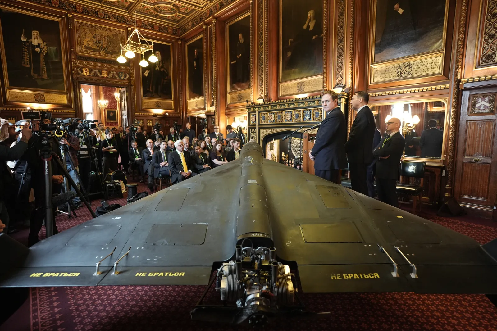 Former U.K. security minister Tom Tugendhat (third right) and Polish Foreign Minister Radek Sikorski (second right), address attendees in front of a downed Russia-operated Shahed-136 attack drone during a press conference at the House of Commons, Westminster, on October 14, 2025.