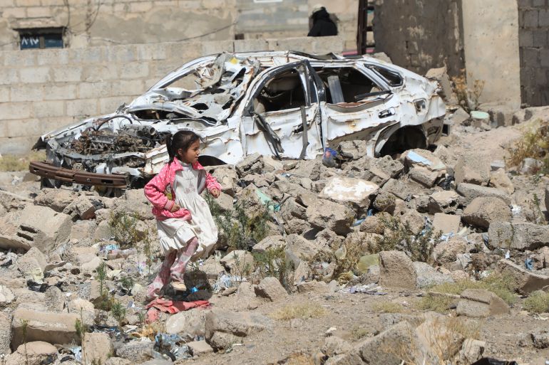 A girl runs over the rubble of a building and car remains, hit by a Saudi led coalition airstrikes in 2015, during an event commemorating the airstrikes ninth anniversary, in Sanaa, Yemen, Thursday, March 26, 2026. (AP Photo/Osamah Abdulrahman)