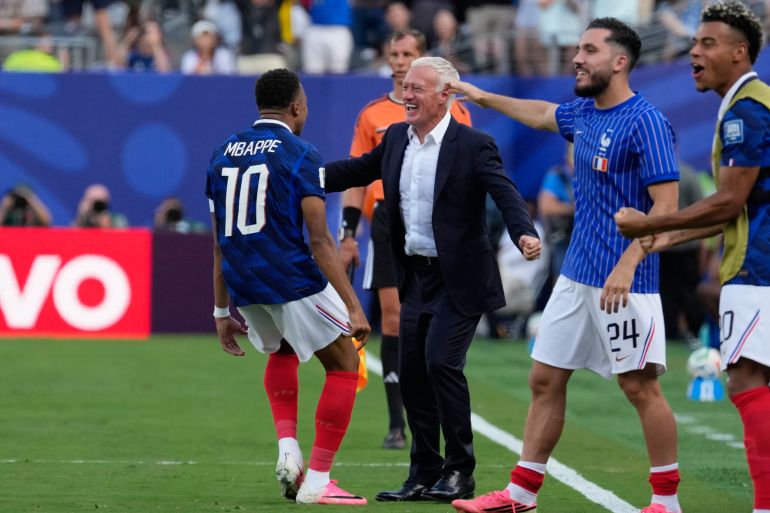 France's Kylian Mbappe, left, celebrates with his coach Didier Deschamps after scoring his side's opening goal during the World Cup round of 32 soccer match between France and Sweden in East Rutherford, N.J., near New York, Tuesday, June 30, 2026. (AP Photo/Seth Wenig)