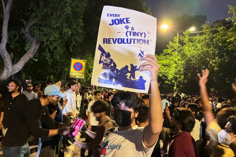 A protester holds a placard with the message "Every Joke is a Tiny Revolution" during a demonstration demanding educational reforms as part of the Cockroach Janta Party's ongoing protest movement in New Delhi, India on July 23, 2026.