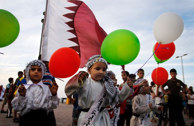 Palestinian children wave colored balloons and Qatari flags while waiting for the convoy of Emir of Qatar Sheikh Hamad bin Khalifa al-Thani, not pictured, to pass by a street in Gaza City, Tuesday, Oct. 23, 2012. The emir of Qatar received a hero's welcome in Gaza on Tuesday, becoming the first head of state to visit the Palestinian territory since the Islamist militant Hamas seized control there in 2007. (AP Photo/Hatem Moussa)