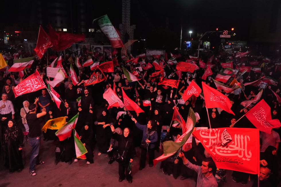 Pro-government demonstrators wave Iranian and religious flags in a gathering commemorating the...