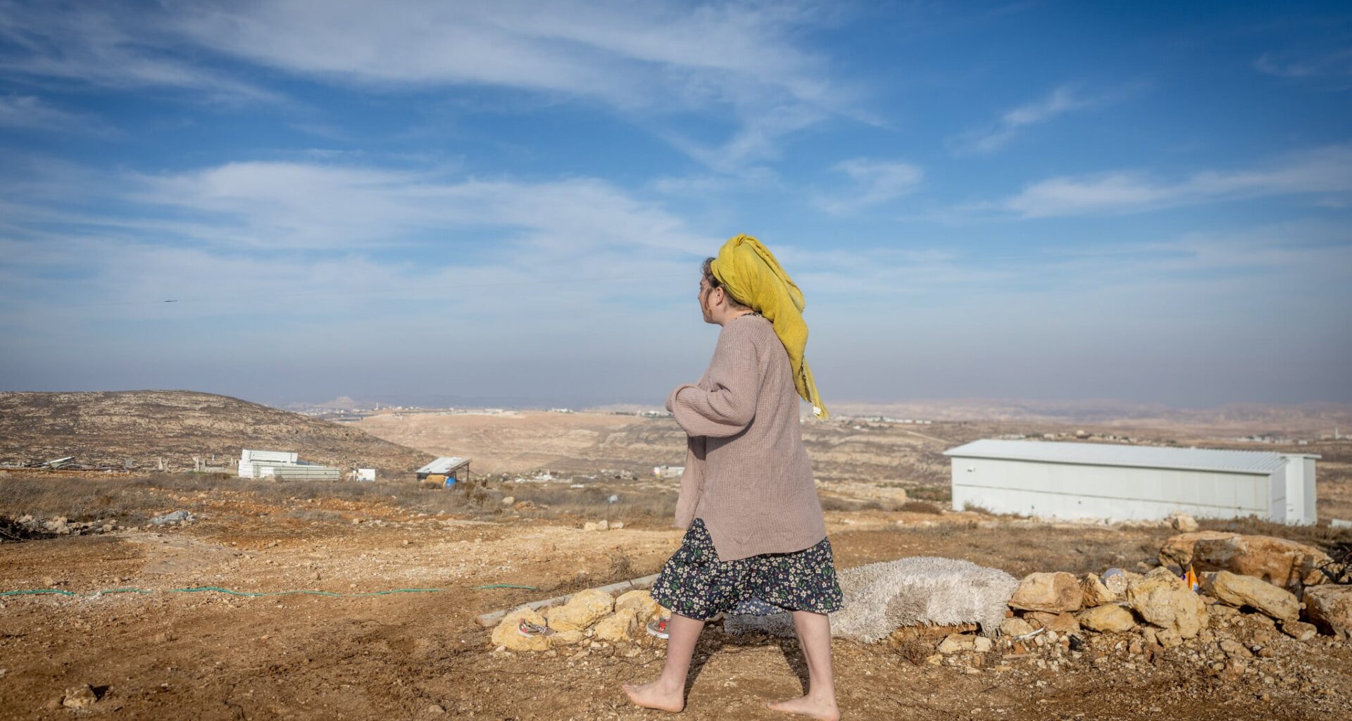 A woman walks near Tzur Misgavi, an illegal outpost in Gush Etzion, in the West Bank, November 17, 2025. (Chaim Goldberg/Flash90)