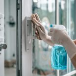 Deep cleaning glass door handles for Covid-19 disease prevention. alcohol,disinfectant spray on Wipes of Banister in home for safety,infection of Covid-19 virus,contamination, germs - stock photo
