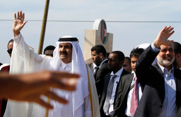 GAZA CITY, GAZA - OCTOBER 23: The Emir of Qatar Sheikh Hamad bin Khalifa al-Thani (L) and Hamas Prime Minister Ismail Haniyeh of the Palestinian National Authority wave to the crowd as they arrive to a cornerstone-laying ceremony of a Qatari funded rehabilitation center October 23, 2012 in Gaza City, Gaza. The Emir of Qatar received a hero's welcome in Gaza, becoming the first head of state to visit the Palestinian territory since the Islamist militant Hamas seized control there in 2007. (Photo by Hatem Moussa-Pool/Getty Images)