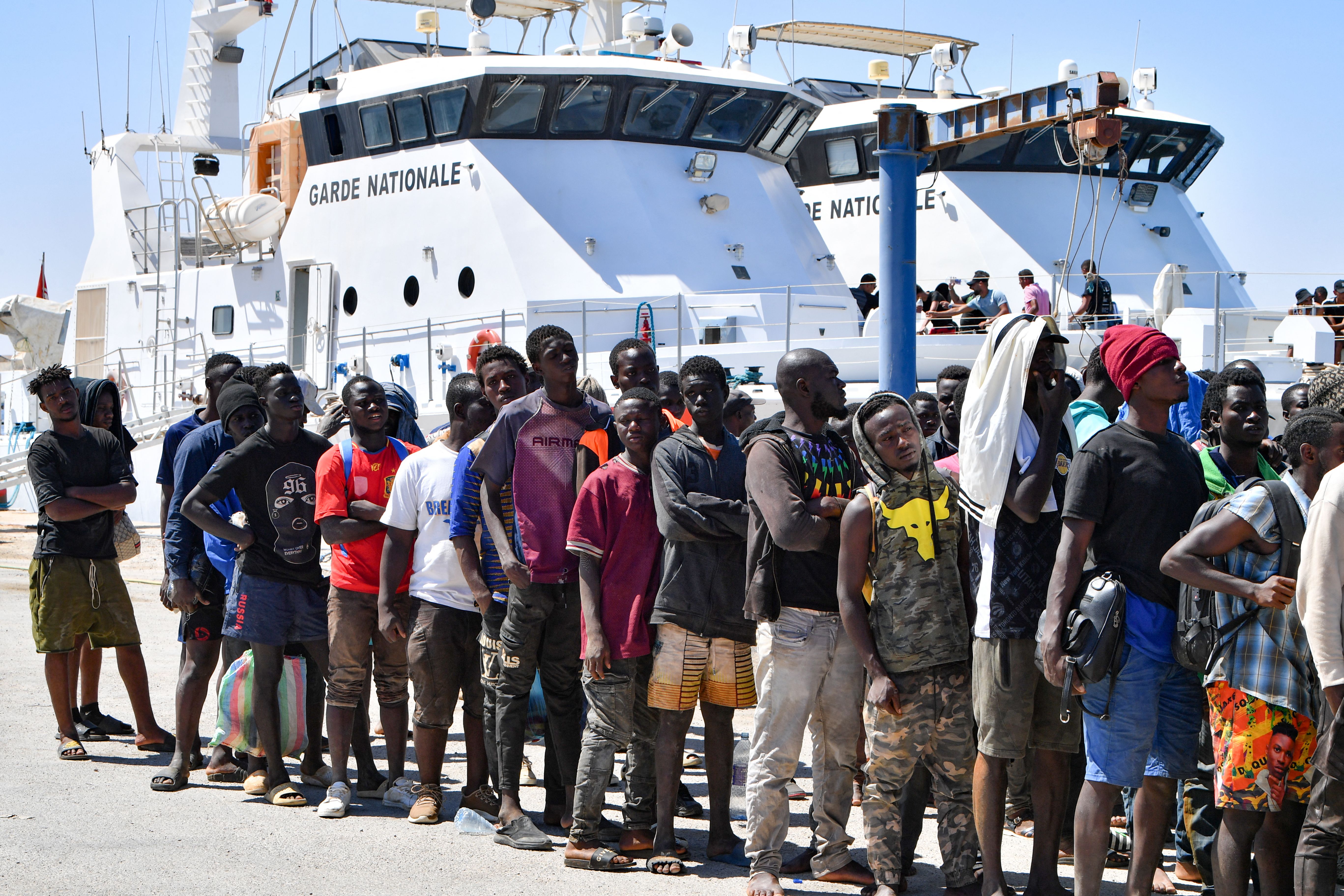 Migrants trying to flee to Europe, disembark in Sfax from a ship owned by the Tunisian coastguards, after being intercepted by them at sea on 10 August 2023.