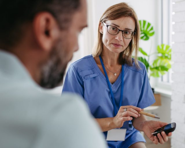 Diabetologist doctor waiting for result from glucose testing in diabetes clinic. - stock photo