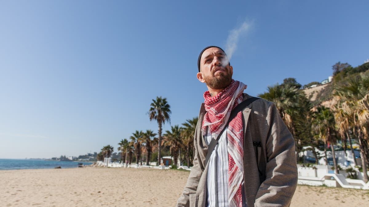 Fergie Chambers smokes a cigarette while posing in Tunis, Tunisia.