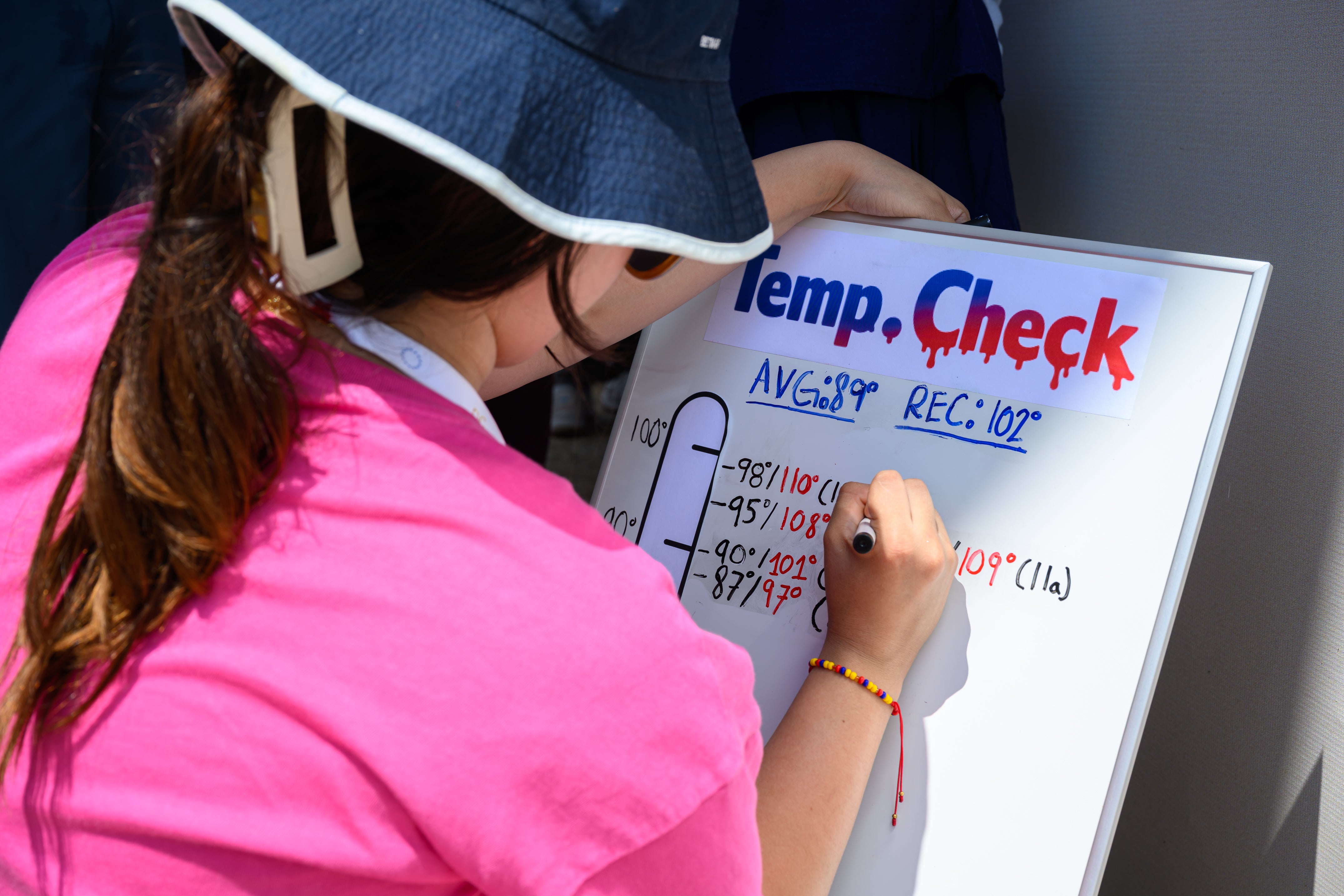 A person records the temperature at the state fair