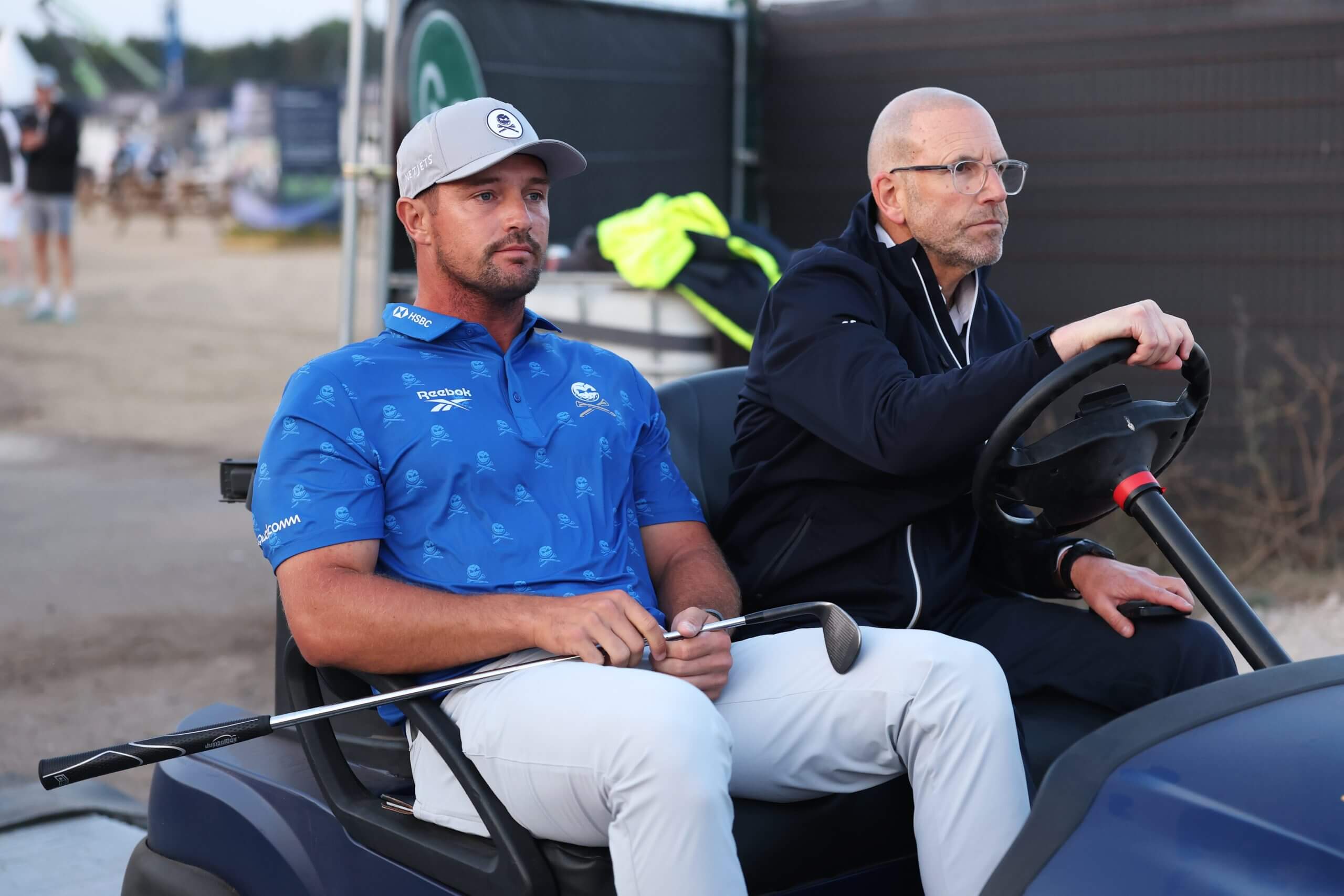 Bryson DeChambeau, left, and R&A rules official Grant Moir ride a buggy back to the scoring area on Friday at The Open Championship.