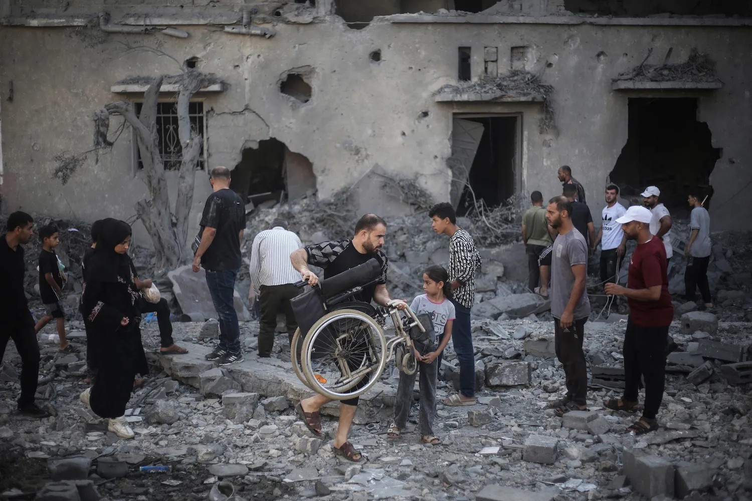 Palestinians inspect damaged and destroyed buildings that were targeted by Israeli strikes the previous night in Deir al-Balah, central Gaza Strip, on July 29.