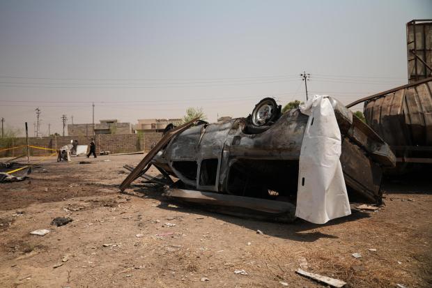 A damaged vehicle at the site of an airstrike on a Popular Mobilization Forces base.