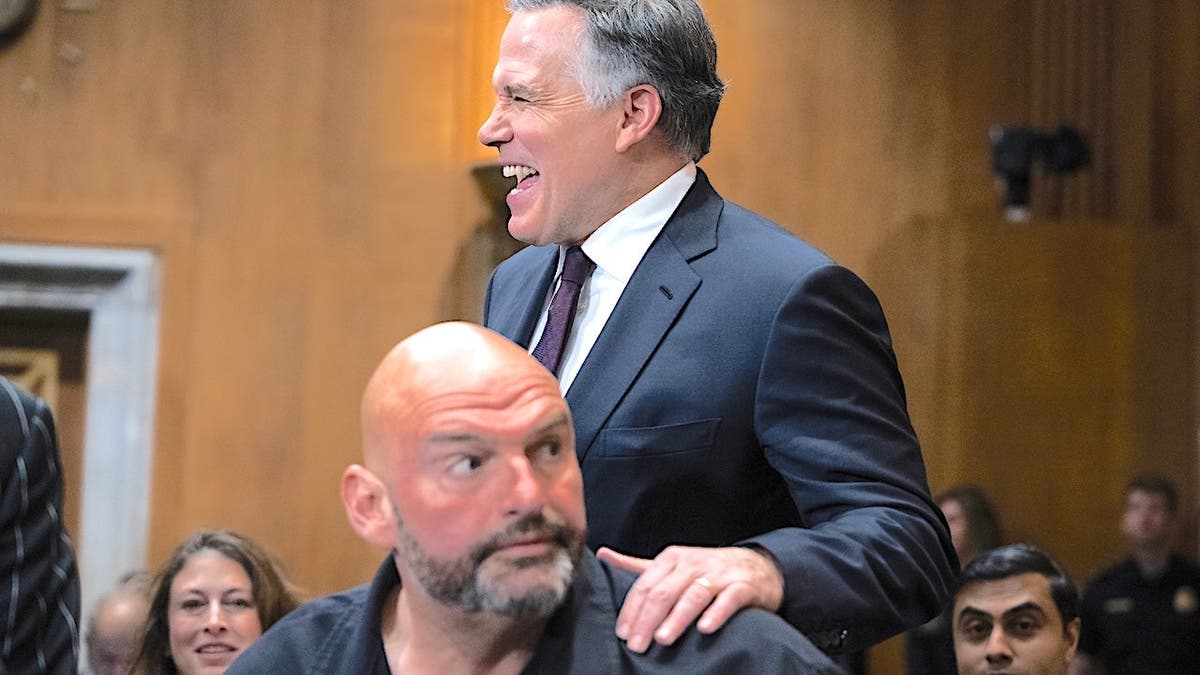 Dave McCormick is laughing and has his hand on John Fetterman