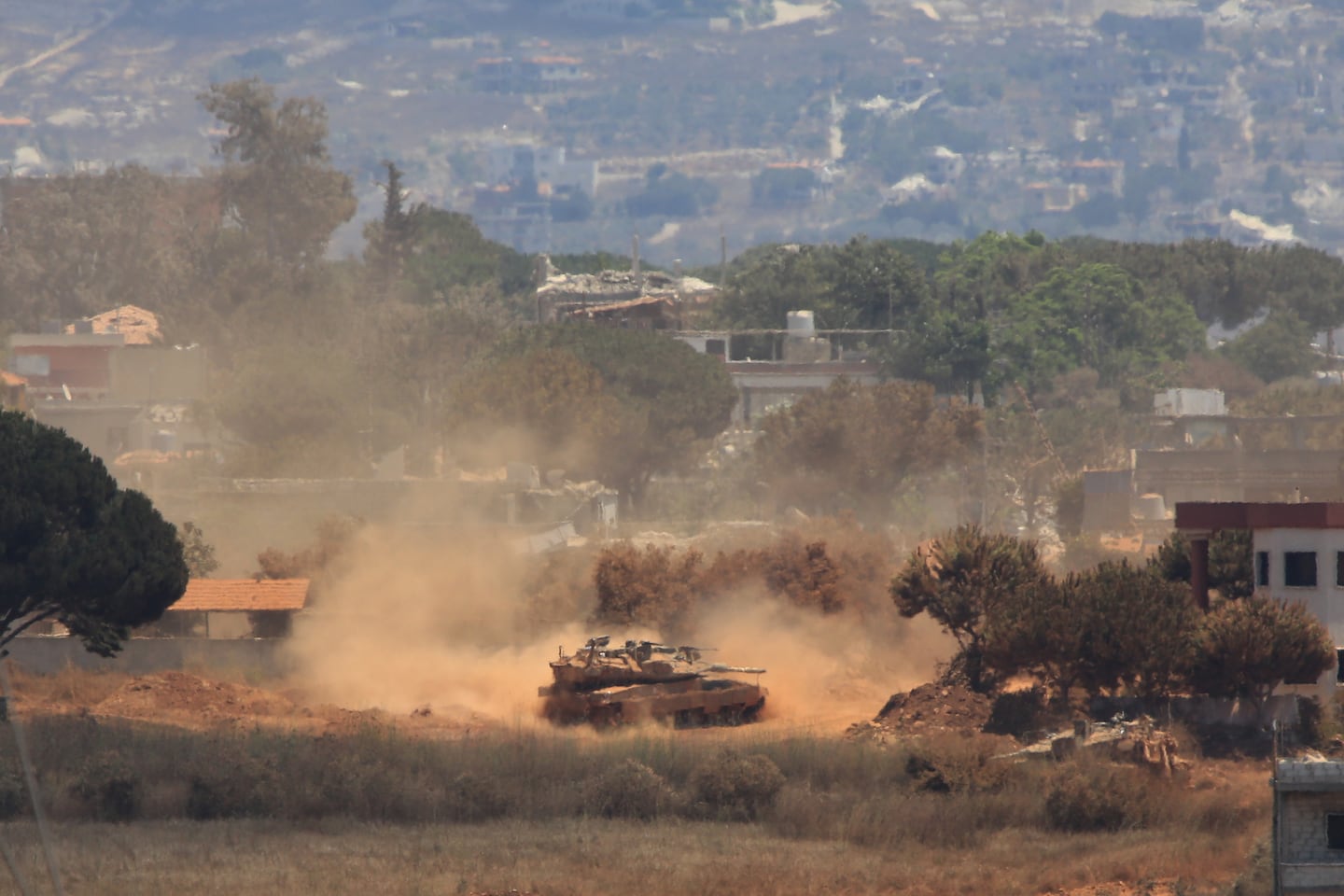 An Israeli tank drove through Zawtar al-Sharqiyah village, occupied by Israeli forces, as seen from the southern village of Zawtar al-Gharbieh, Lebanon, on Monday.