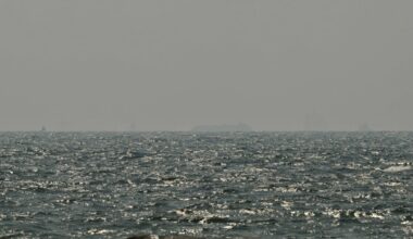 Ships are seen in the horizon as they sail off the coast of Ajman on July 10, 2026. Traffic through the Strait of Hormuz has fallen sharply since July 8, especially through the UN-backed Omani route, analysts said, after vessels were attacked earlier this week and as the United States and Iran traded renewed strikes.