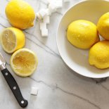 Fresh lemons and sugar cubes on marble counter top