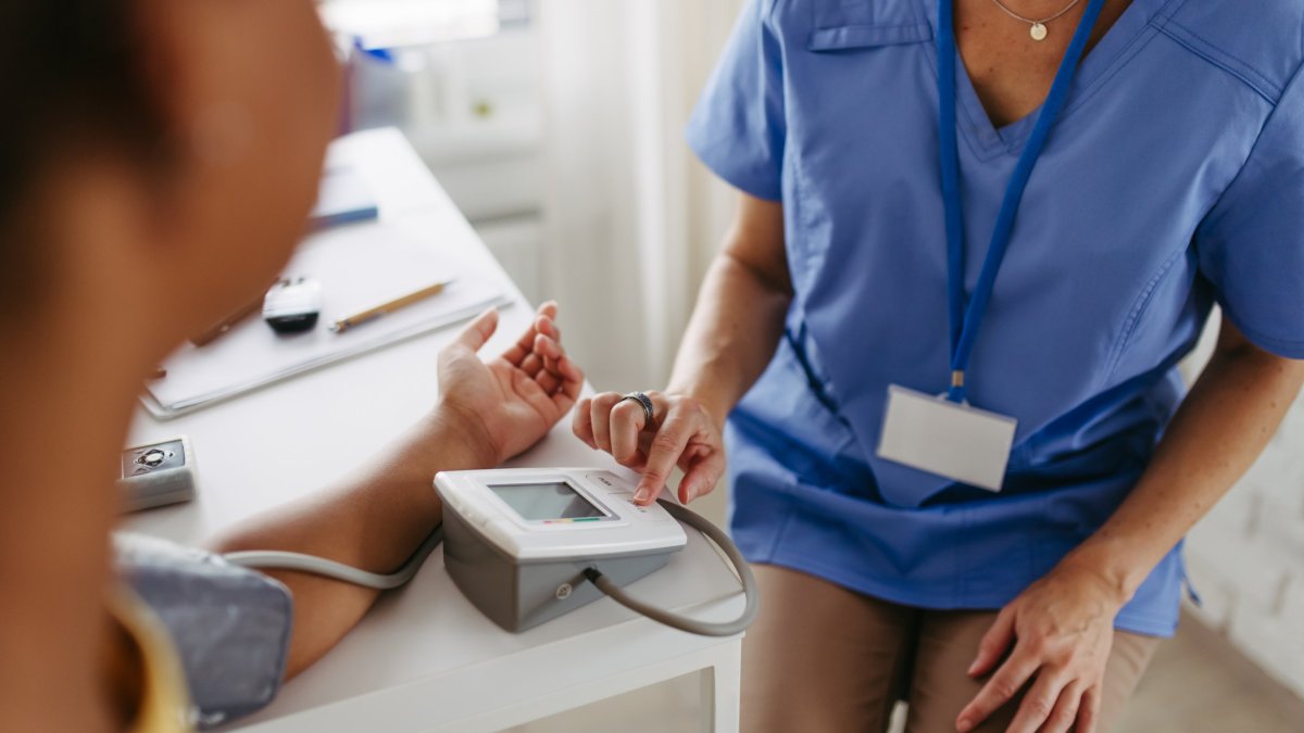 Doctor measuring teen patient's blood pressure. Examining hypertension in diabetic teenage girl. Girl visiting paediatrician for annual preventive examination, check-up.