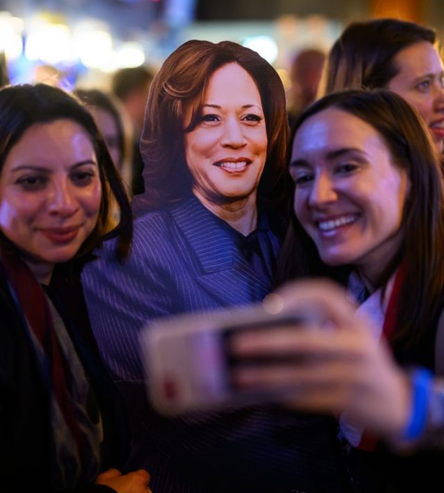 LONDON, ENGLAND - NOVEMBER 05: People pose with a cardboard standee of Democratic Presidental nominee Kamala Harris as they attend a 