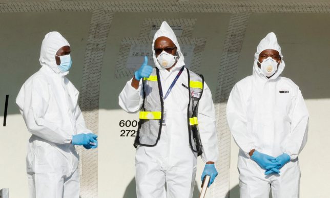 European Commission Civil Protection and Humanitarian Aid Operations (ECHO) crew dressed in Personal Protective Equipment (PPE) gesture after loading essential medical supplies and emergency kits on an aircraft to support the affected regions in Bunia, Ituri province, amidst the Ebola outbreak in the Democratic Republic of Congo, at the Jomo Kenyatta International Airport (JKIA) in Nairobi, Kenya, June 4, 2026. REUTERS/Monicah Mwangi