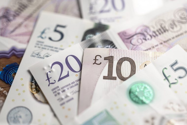 Different denominations of British PoundNotes with newly minted one pound coins