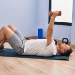 This is a photo of a man lying on a yoga mat about to do chest presses with dumbbells. See PA Feature HEALTH Back Exercises WARNING: This picture must only be used to accompany PA feature HEALTH Back Exercises. PA Photo. Picture credit should read: Alamy/PA. NOTE TO EDITORS: This picture must only be used to accompany HEALTH Back Exercises.