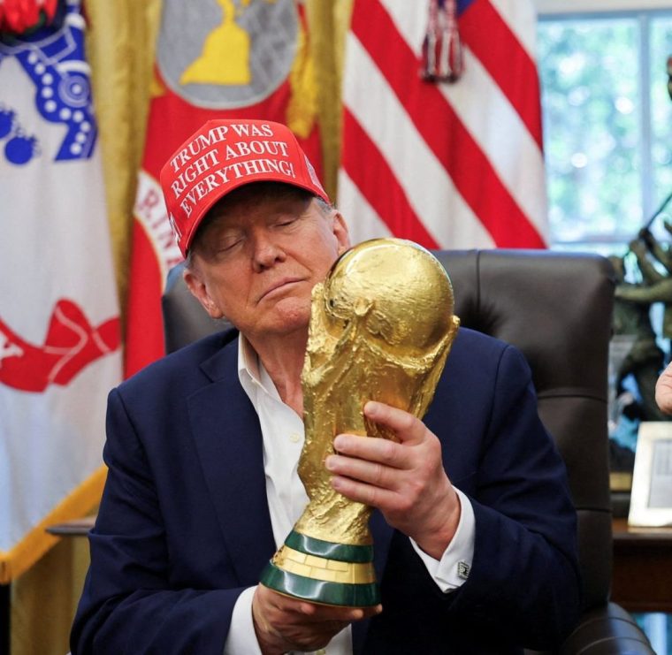 FILE PHOTO: U.S. President Donald Trump holds the FIFA World Cup Trophy, as he makes an announcement on the 2026 FIFA World Cup, as FIFA president Gianni Infantino stands next to him, in the Oval Office at the White House in Washington, D.C., U.S., August 22, 2025. REUTERS/Jonathan Ernst/File Photo