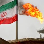FILE PHOTO: A gas flare on an oil production platform in the Soroush oil fields is seen alongside an Iranian flag in the Persian Gulf, Iran, July 25, 2005. To match Exclusive OPEC-OIL/ REUTERS/Raheb Homavandi/File Photo/File Photo