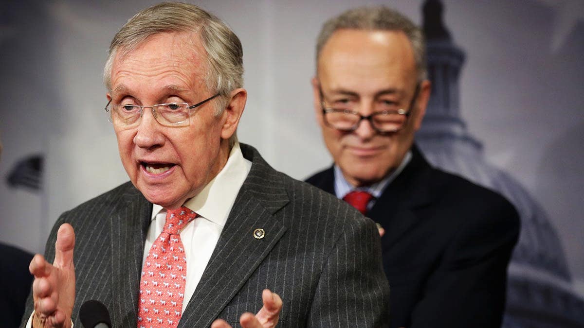 Harry Reid speaks as Charles Schumer listens at a news conference.