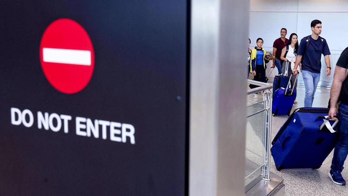 Travelers arrive at Miami International Airport.