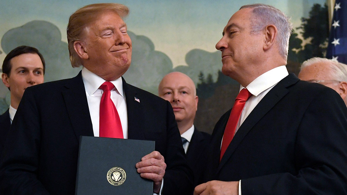 Donald Trump smiles at Israeli Prime Minister Benjamin Netanyahu, right, after signing a proclamation at the White House in Washington.